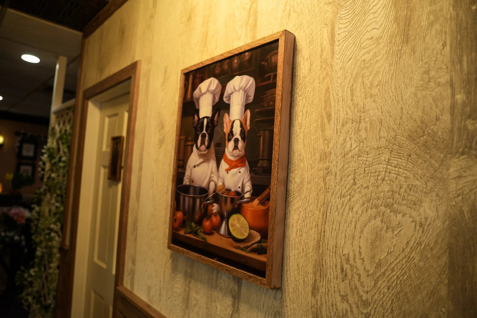 Framed chef-themed artwork on the wall at Ciminelli's Pizzeria in Bethpage